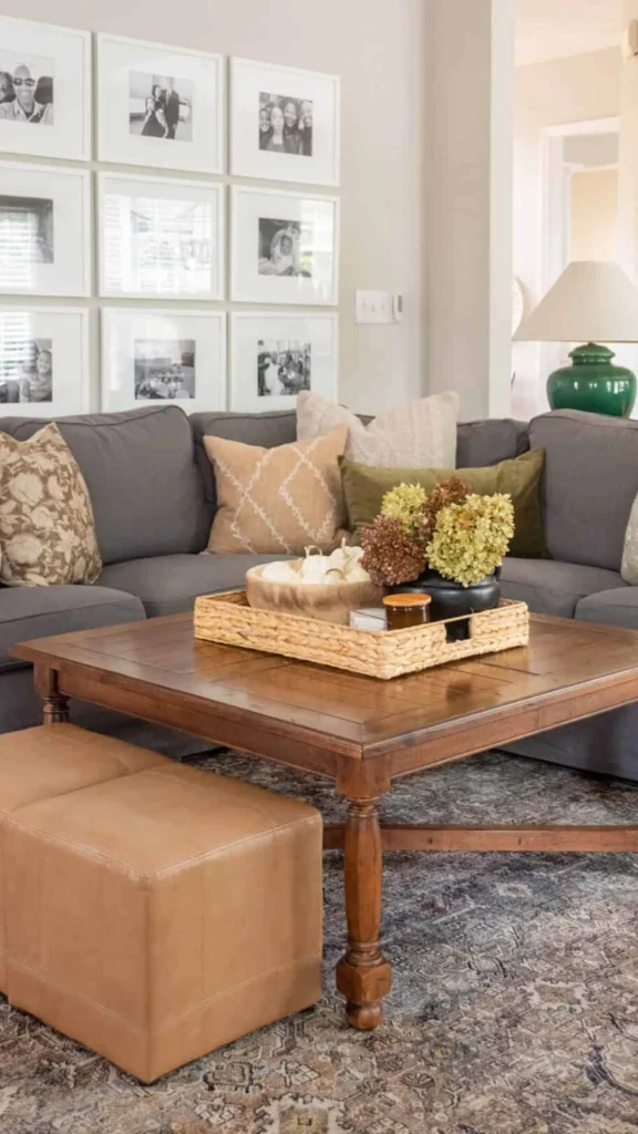 Transitional family room featuring a grey sectional sofa, a photo gallery wall, and a dark wood coffee table for personalized home decor ideas.