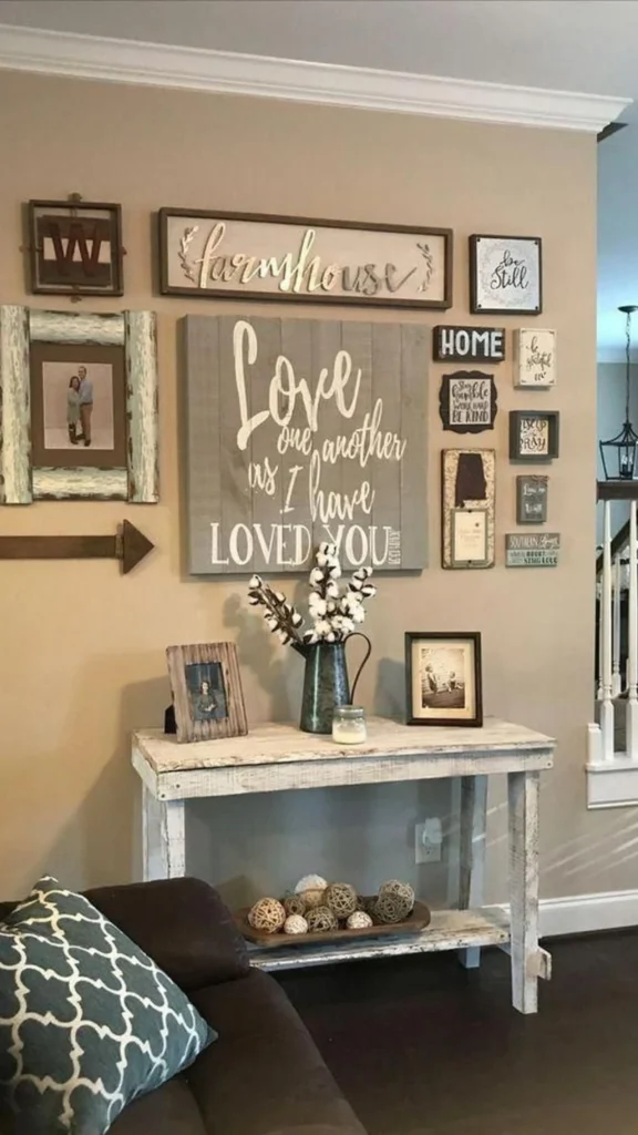 Farmhouse entryway featuring a distressed wood console table, a large "Love one another" sign, and a gallery wall showcasing welcoming home decor ideas.
