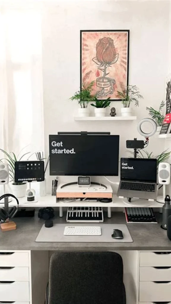 Small tech workstation featuring home office decor ideas with a white desk riser, studio speakers, ring light setup, laptop stand, and potted succulents.