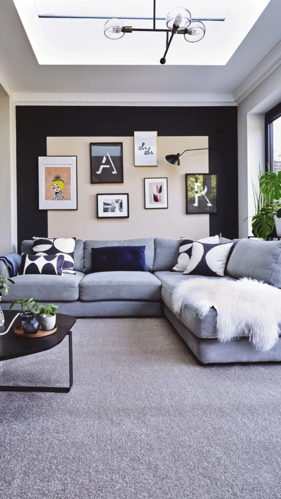 Contemporary living room displaying wall decor ideas with a black accent wall framing modern typography art behind a grey sectional sofa.