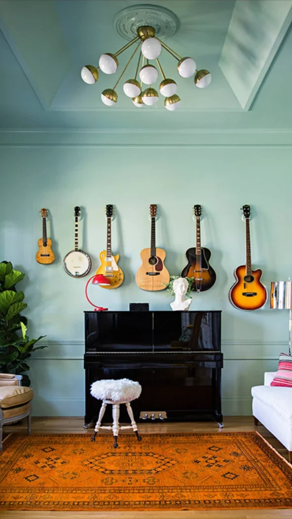 Mint green music room featuring wall decor ideas with six string instruments mounted in a row above an upright piano and orange rug.
